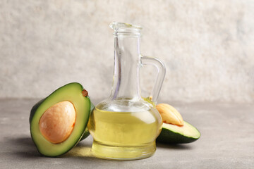 Jug of avocado oil on grey background