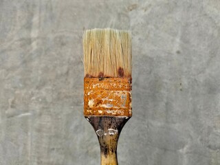 rusty paint brush on cement wall background 