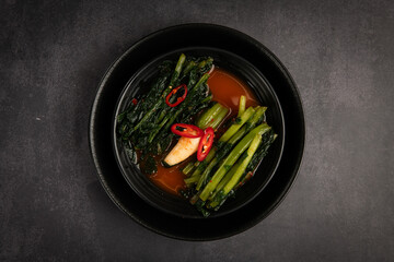 Japanese kimchi soup in bowl on dark background, top view