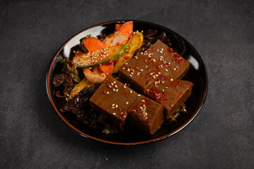 Korean traditional food Stir-fried tofu with vegetables on black background