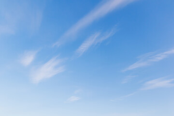 Clear blue sky with wispy white clouds