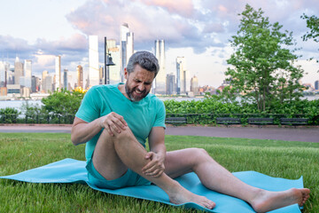 Knee after sport. Athletic man suffering from knee pain. Injured man holding leg. Pain after...