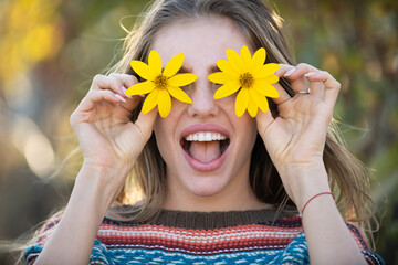 Spring face. Flower model portrait. Girl with funny expression. Fun woman in nature. Romantic flower portrait. Beautiful girl with blossom. Woman with floral smile. Funny summer face portrait.