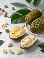 Halved Jackfruits Showcase Yellow Arils Surrounded by Whole Fruits and Green Leaves