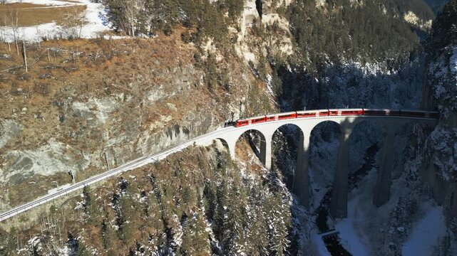 Die R&auml;htische Bahn f&auml;hrt mit einem Zug &uuml;ber das traumhaft sch&ouml;ne Landwasserviadukt