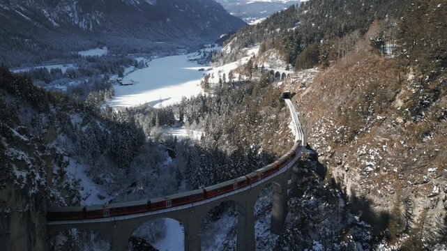 Die R&auml;htische Bahn f&auml;hrt mit einem Zug &uuml;ber das traumhaft sch&ouml;ne Landwasserviadukt