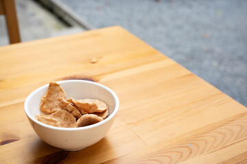 Crispy in Chips bowl savory simple delicious snack golden brown texture munching wooden table, the fried appetizer thin round chips rustic light, serve classic treat felt truly homemade.