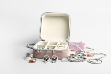 Organizer with beautiful silver jewelry and gift box on grey background