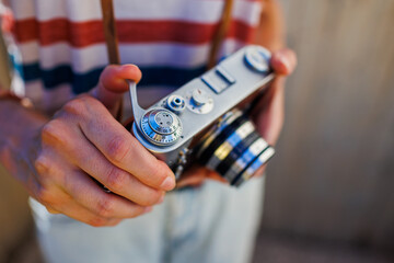 young girl with a camera.  the photographer adjusts the camera. Stylish girl with a film camera. film camera close up.
