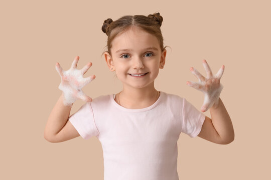 Little girl with foam on beige background
