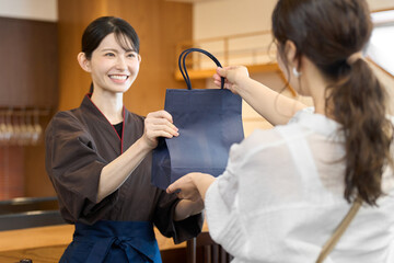 商品を渡す飲食店の従業員