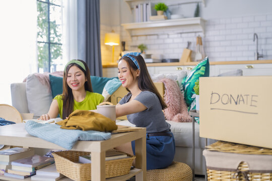 Organizing donations with friends in cozy living room, surrounded by boxes and home decor. atmosphere is cheerful and collaborative