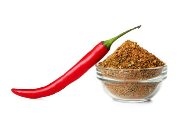 Bowl of powdered spice and chili pepper on white background