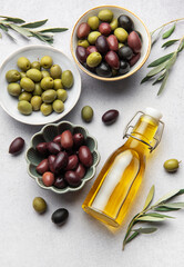 Assorted olives with olive oil and olive branches creating culinary delight