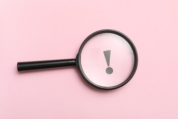 Exclamation mark visible through magnifier on pink background