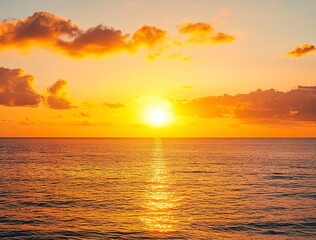Fototapeta premium Beautiful sunset over the sea with an orange sky and golden clouds. Stunning seascape, ocean view with the sun setting in summer. Sunset background for design, print, or postcard.