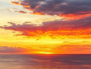 Fototapeta premium Beautiful sunset over the sea with an orange sky and golden clouds. Stunning seascape, ocean view with the sun setting in summer. Sunset background for design, print, or postcard. 