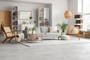 Bookcases, cozy sofa, wicker armchairs and coffee table in interior of modern living room