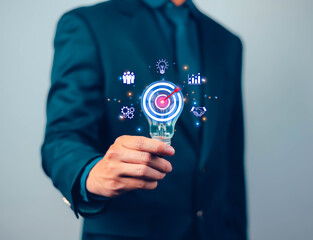 
Businessman holding creative light bulb idea with network icons of industry and marketing development goals. Strategic planning, success, target, aim.