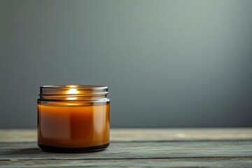 Glowing amber jar candle creates cozy atmosphere on rustic wood table for relaxation and meditation.