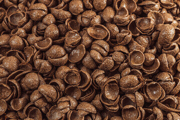Close-up of crispy chocolate cereal pieces forming a textured background, ideal for breakfast and food-related concepts.