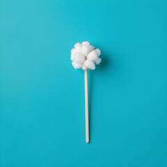 Cotton Balls on Wooden Stick against Teal Background