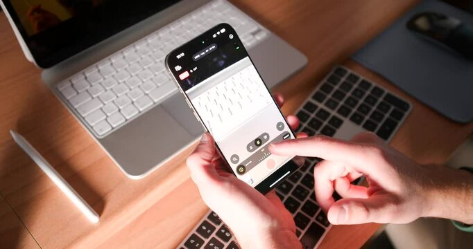 Hands Editing Video On iPhone With Final Cut Pro Software. iPad In Background. high angle shot