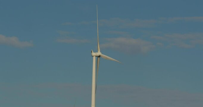 mid shot of wind turbine rotating with blue sky on the A A4061 at Hendre'r Mynydd Car Park,