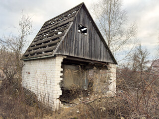 A dilapidated old building with a roof that is missing several pieces
