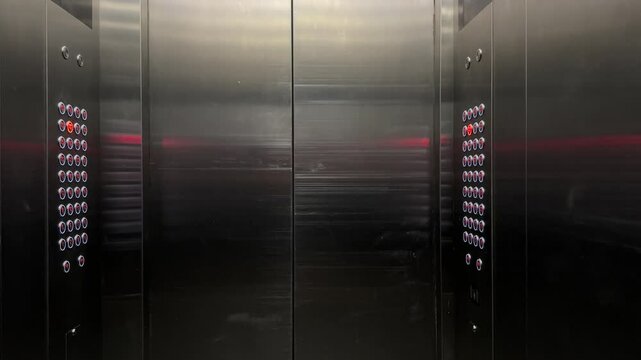 Video of lift interior with rows of buttons on both side. Dark and moody vibes.