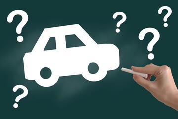 自動車とクエスチョンマークを黒板に描く