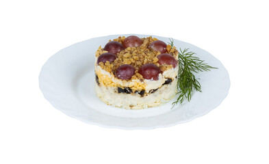 A white plate beautifully topped with a delicious cake featuring grapes on top