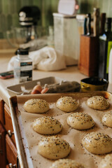 View of messy kitchen with sourdough buns rising on the counter