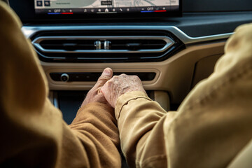An elderly coupld holding hands in their electric vehicle
