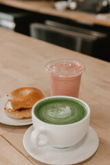 Matcha latte, strawberry smoothie, and bagel with cream cheese
