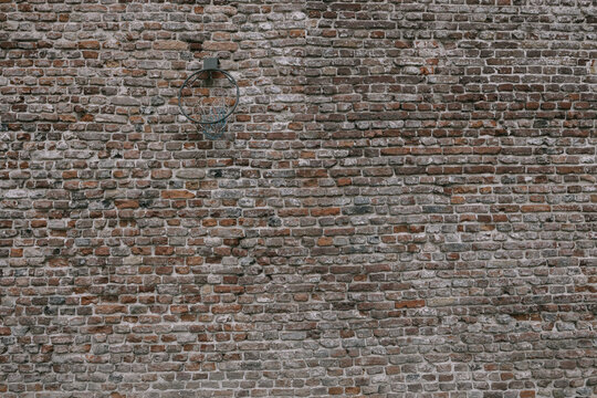 An old brick wall with a basketball hoop