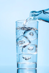 Crystal clear water being poured into a transparent glass, creating refreshing ripples and bubbles
