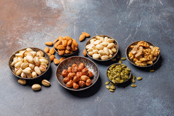 A vibrant assortment of various nuts, including almonds, walnuts, hazelnuts, cashews, and pistachios