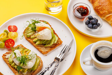 Breakfast with delicious avocado toasts and crispy croissant
