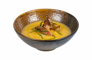 A bowl of soup with bacon and green onions on white