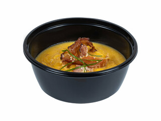 A bowl of soup garnished with crispy bacon on a white background
