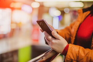 A woman writes in her smartphone at the mall