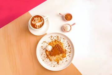 Top shot of Biscuit flavoured cheesecake served with cream and cappuccino coffee.