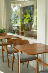 Empty chairs and tables in a cafe with wide glass windows