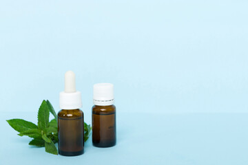 Natural Mint Essential Oil in a Glass Bottle. organic cosmetics with herbal extracts of mint on...