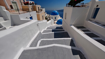 Iconic Santorini staircase gracefully descends toward deep Santorini blue sea under clear sky. Whitewashed steps, flanked by traditional Santorini blue domes, mesmerizing Mediterranean atmosphere