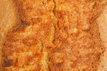 A rustic, golden-brown loaf of homemade bread is captured from an overhead perspective, showcasing...