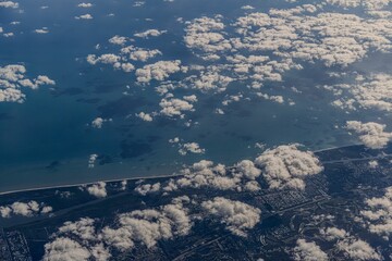 Aerial view of coastal city and clouds. © Wirestock