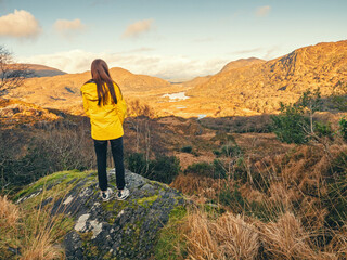 Teenager girl looking at stunning nature scenery from Ladies viewpoint in Killarney, Ireland....