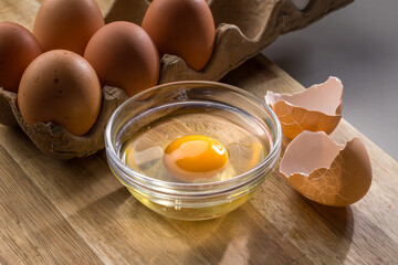 Brown Egg Cracked Open on Wood Board